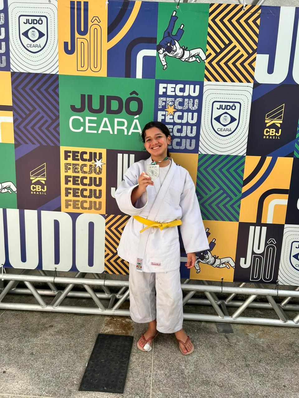 Atleta da Del Sol Academia usando quimono e exibindo sua medalha de Judô